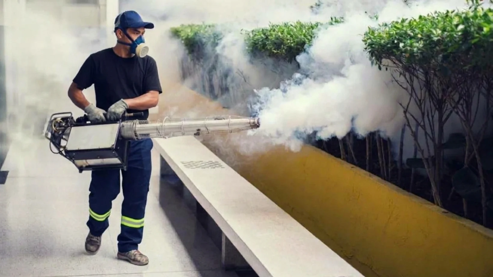 Pest-control technician applying a treatment outdoors