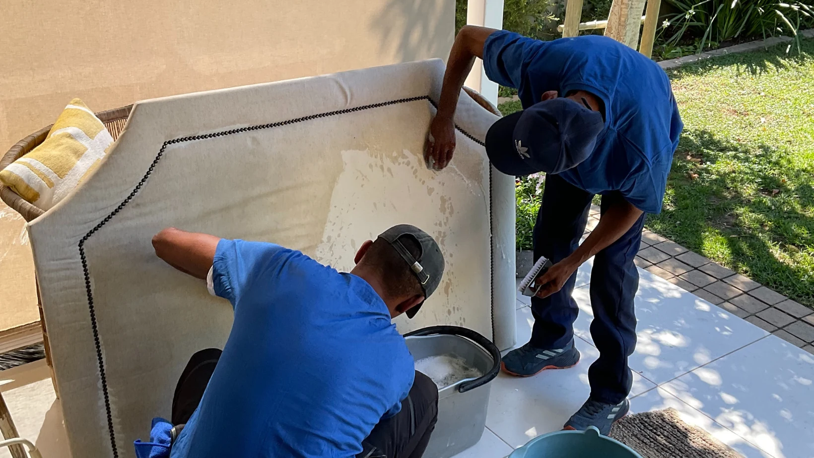 Team cleaning upholstered furniture with extraction equipment