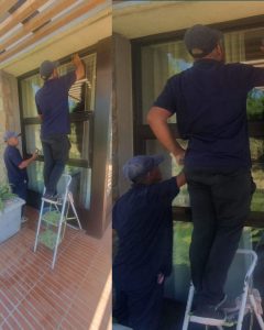 Boland Cleaning team performing detailed residential window cleaning in Franschhoek using step ladder for upper panes.